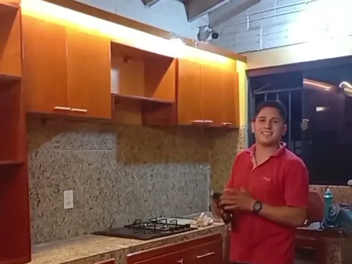 Cocina a medida terminada con alacenas de madera y mesada de granito